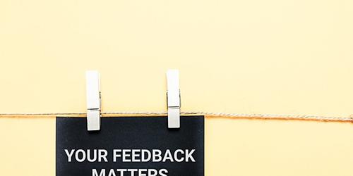 sign pegged on a piece of string, saying 'your feedback matters'